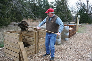 Image of Don Janssen, retired, turning compost bins. 
