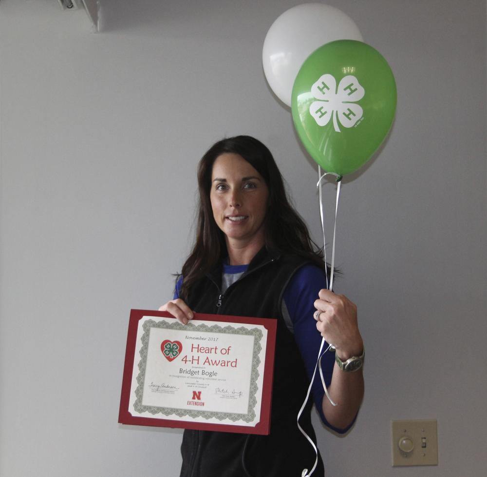 Bridget Bogle holding 4-H balloons and a certificate.