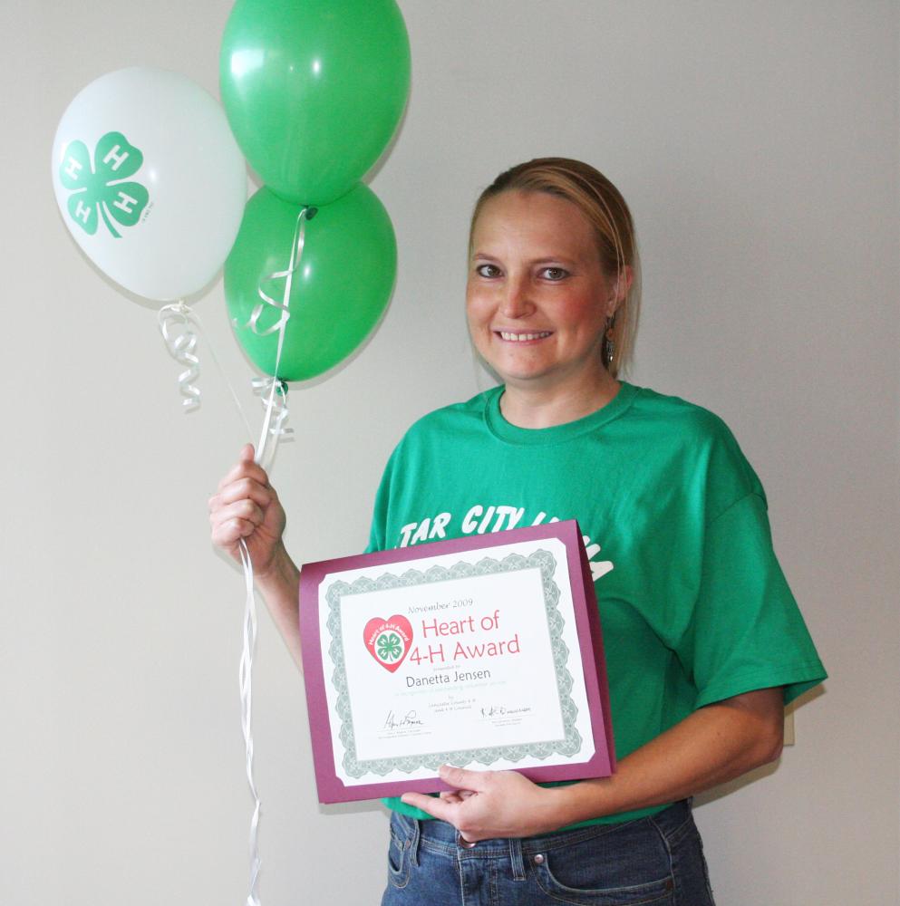 Danetta Jensen holding balloons and a certificate