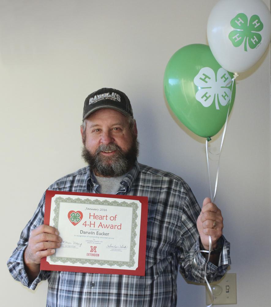 Darwin Eucker holding 4-H balloons and a certificate.
