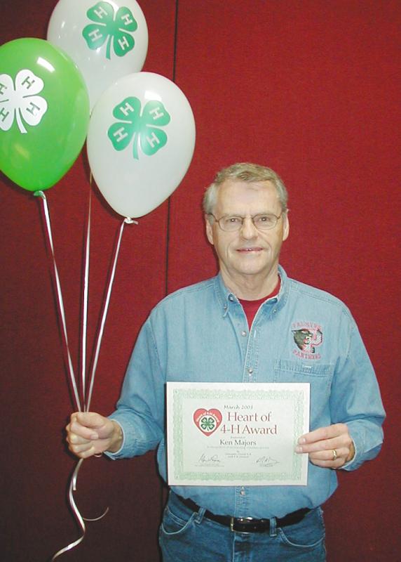 Ken Majors holding balloons and a certificate.