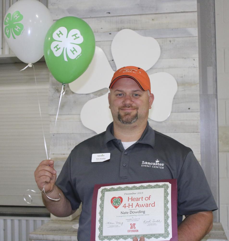 Nate Dowding holding 4-H balloons and a certificate.