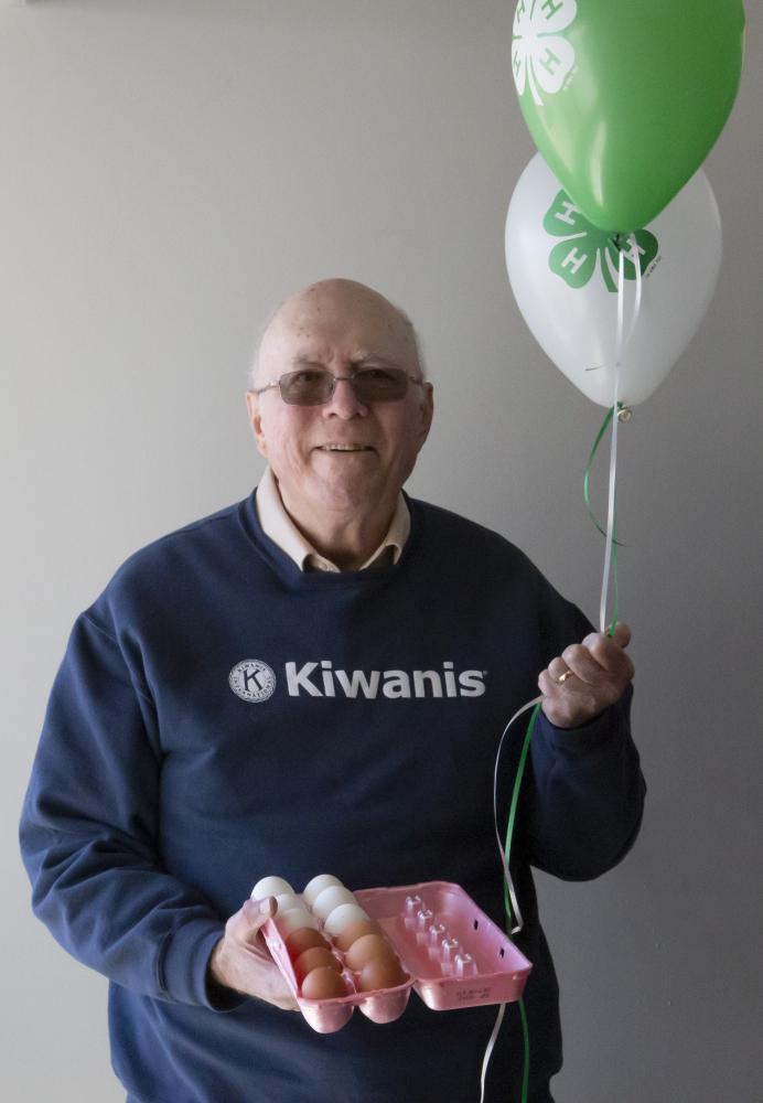 Rick Waldren holding 4-H balloons and a carton of eggs