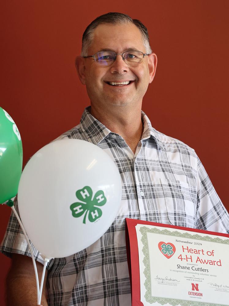 man holding a certificate and balloons