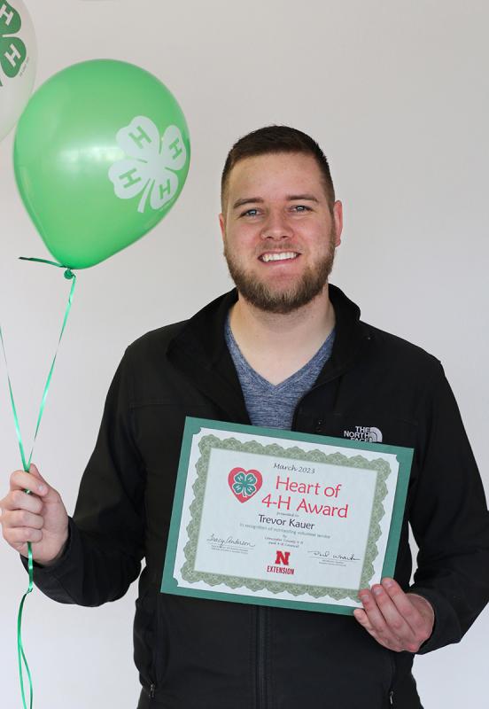 Trevor Kauer holding certificate and 4-H balloons