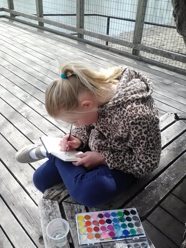 Picture of child writing in a garden journal. 