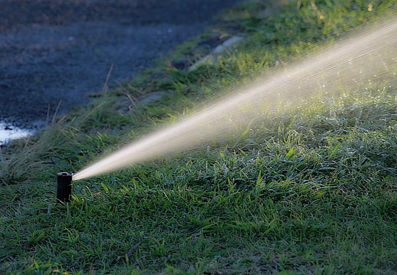 Image of an underground sprinkler spraying turf