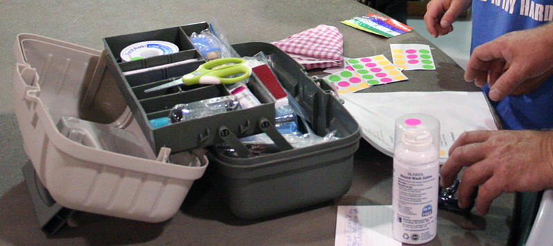 An open first aid kit with supplies such as gauze, scissors, spray