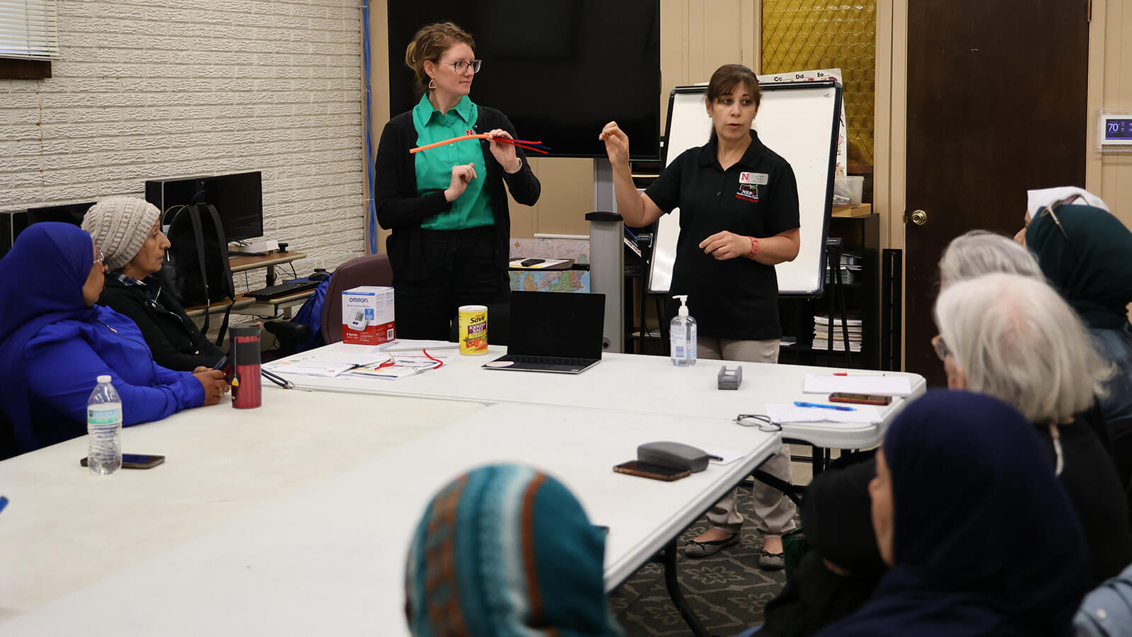 Two educators presenting to several women sitting around tables