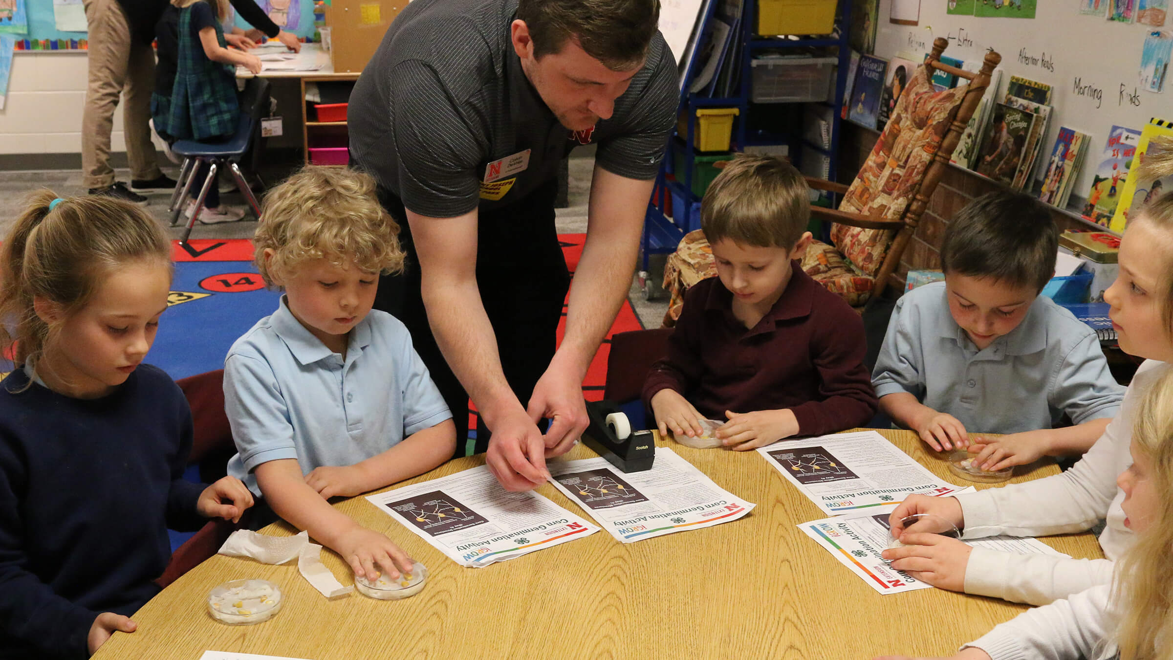 Photo of Calvin DeVries helping children with corn germination activity