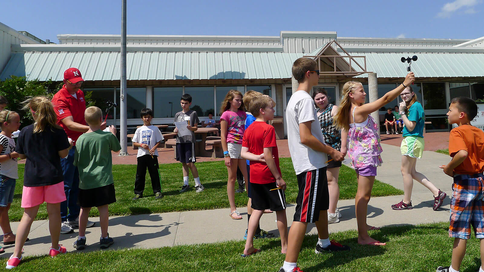 youth and an adult holding wind speed devices