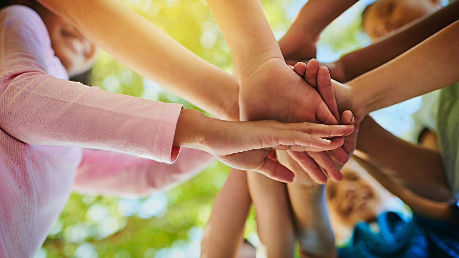 several youth's hands in a circle