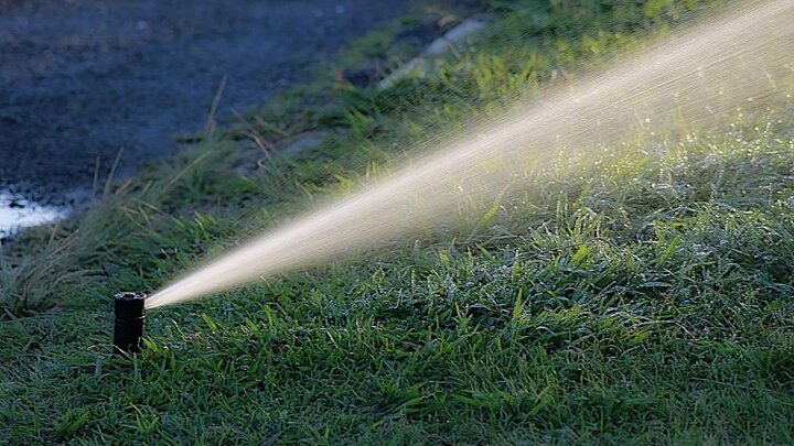 Image of an underground sprinkler spraying turf