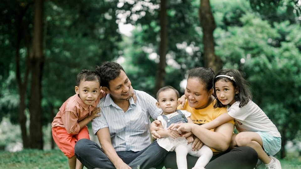 Family smiling in a park