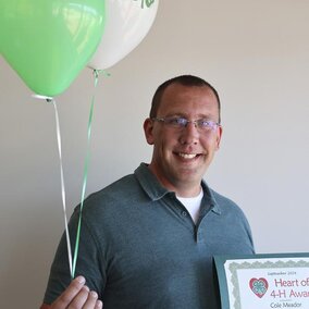 Cole Meader holding certificate and balloons. 