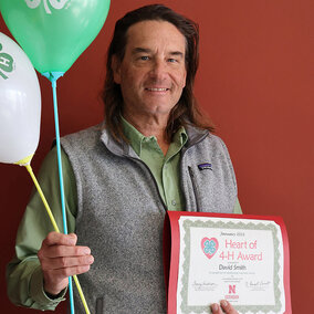 David Smith holding a certificate and balloons