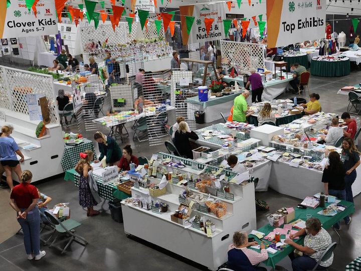 a large room filled with fair displays and exhibits, including food items on plates