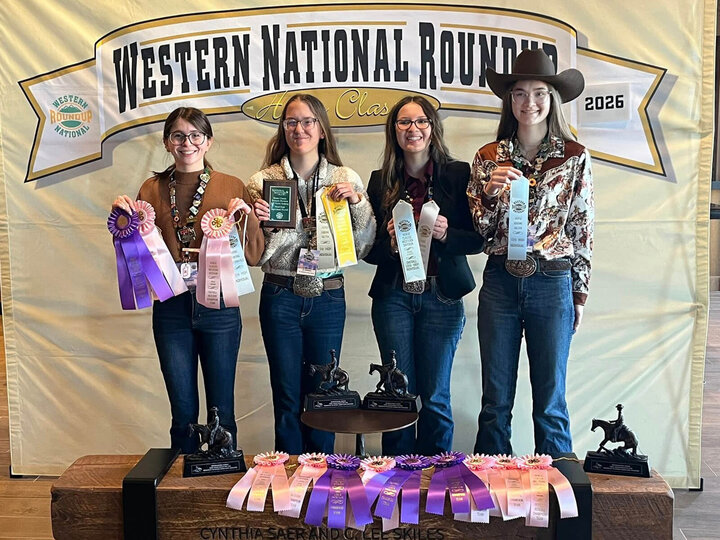 Four teen girls smiling and holding ribbons in front of a background that says Western National Roundup