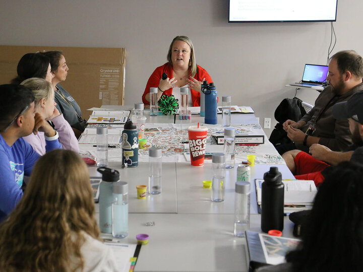 an educator talking to several adults around a table