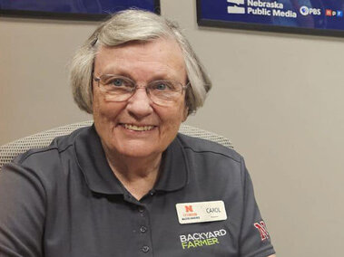 Smiling woman sitting at a desk with a phone in front of her