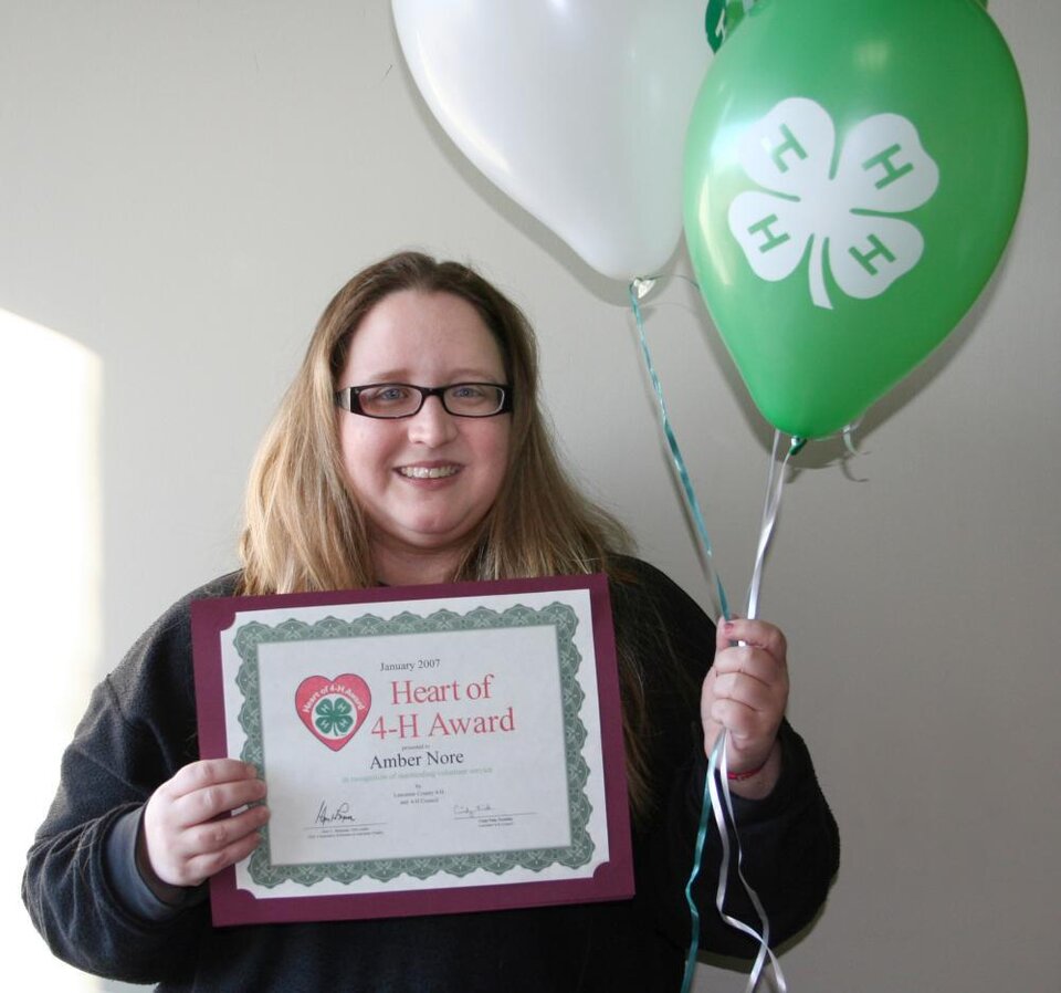 Amber Nore holding balloons and a certificate 