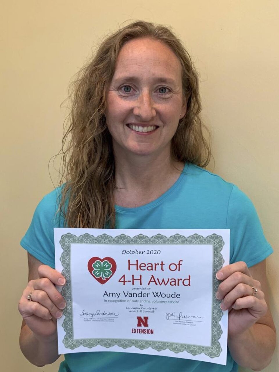 Amy Vander Woude holding a certificate. 