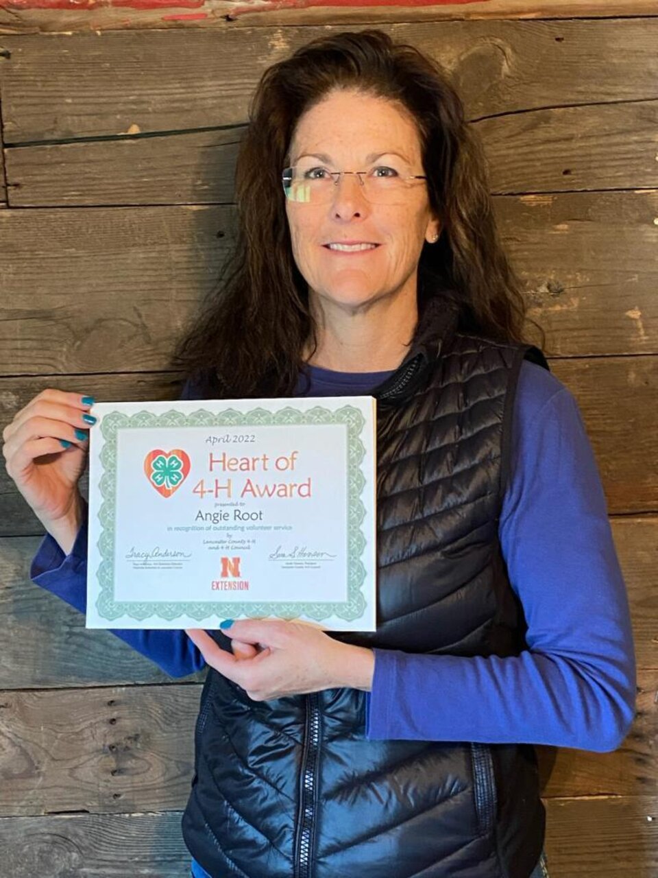 Angie Root holding a certificate. 