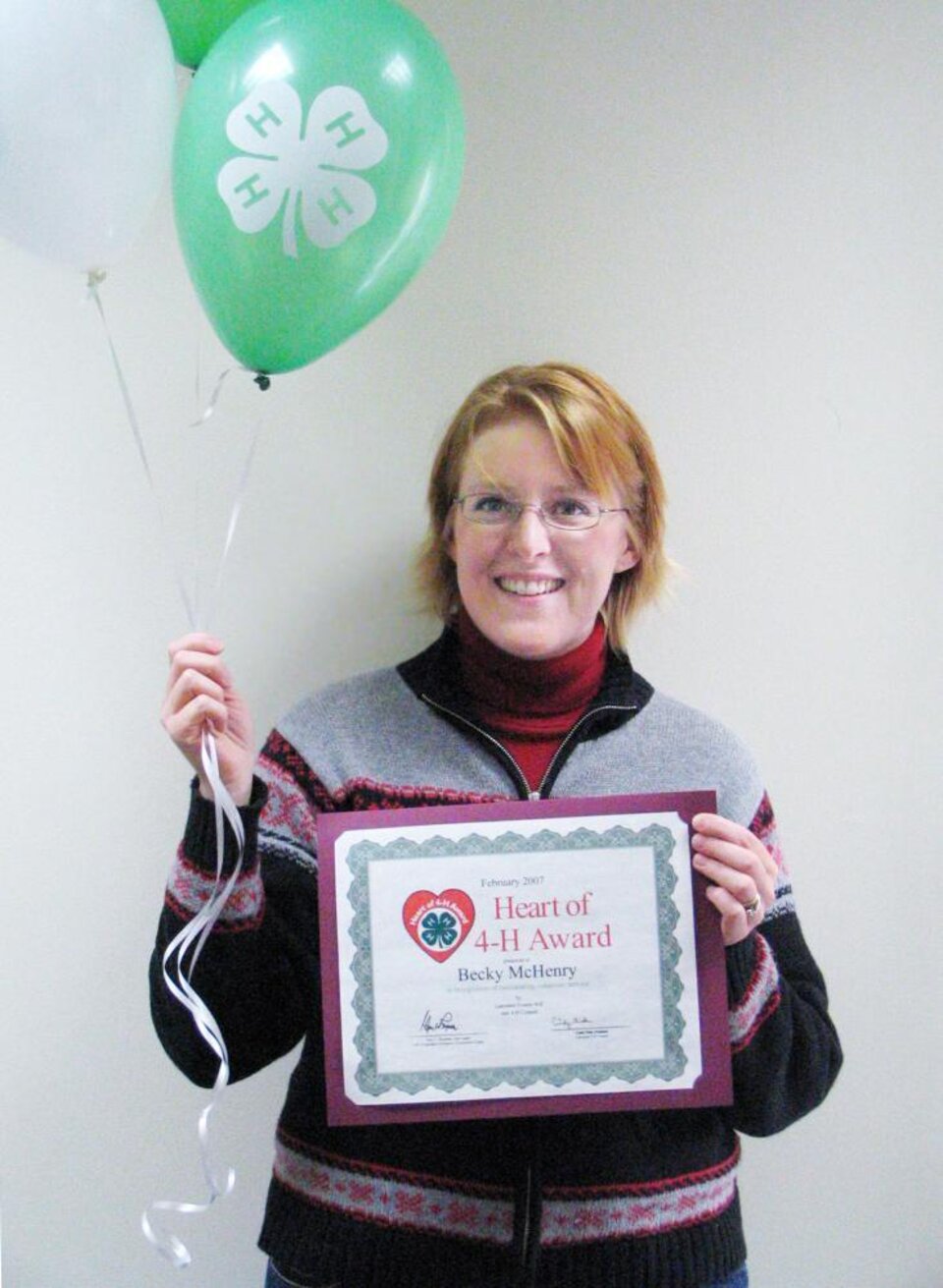 Becky McHenry holding balloons and a certificate 