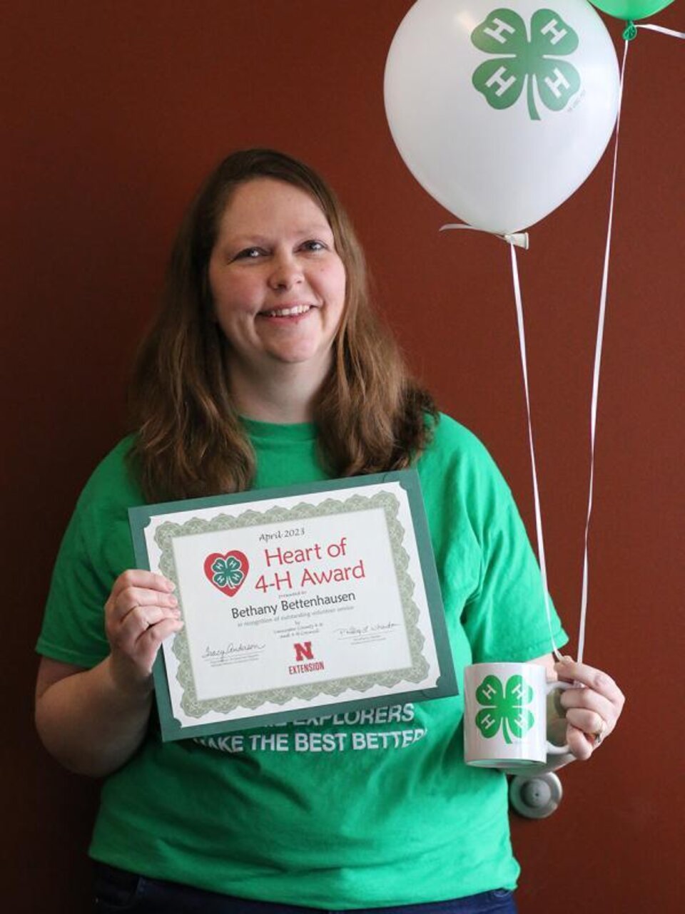 Bethany Bettenhausen holding certificate and balloons 