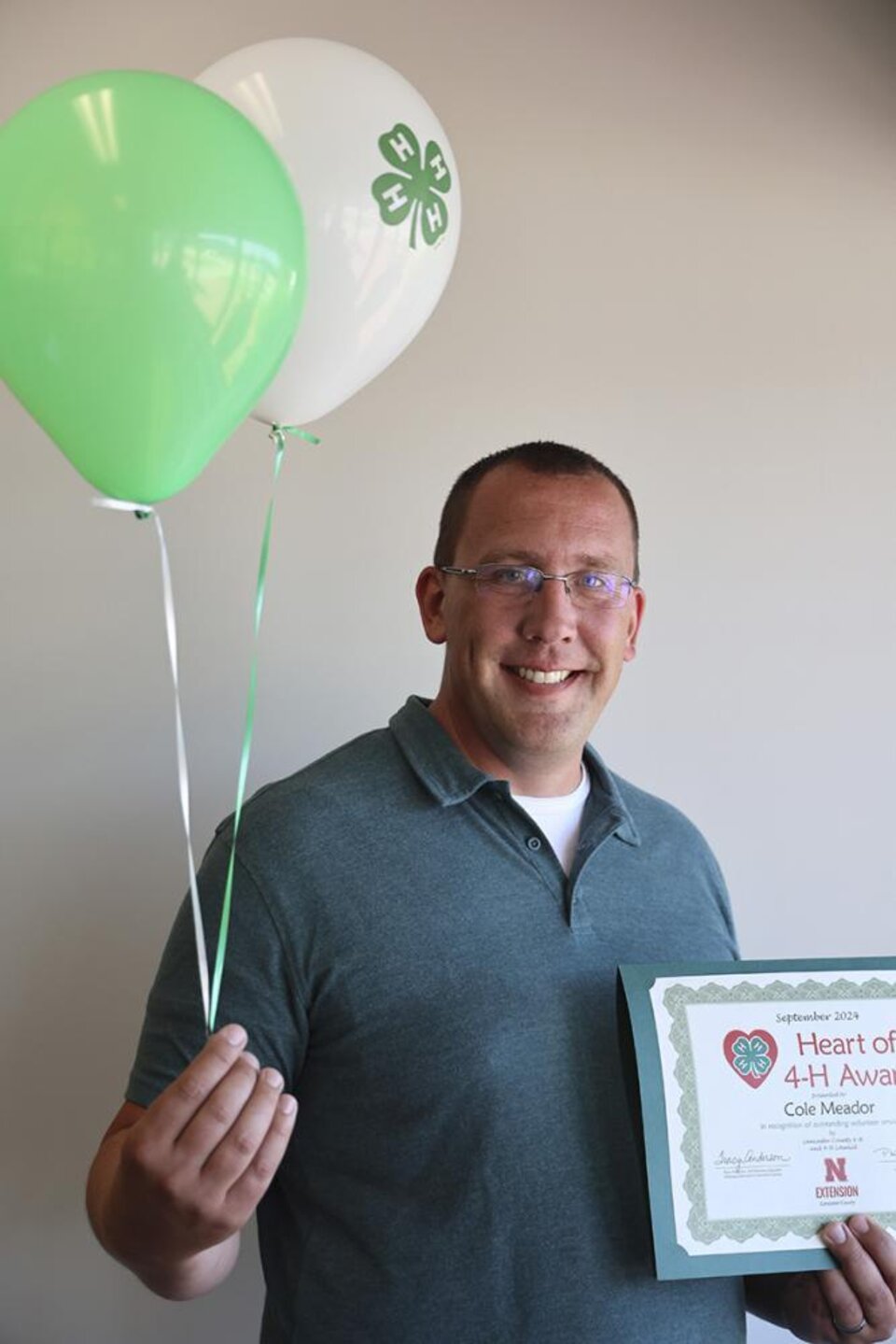 Cole Meader holding certificate and balloons. 