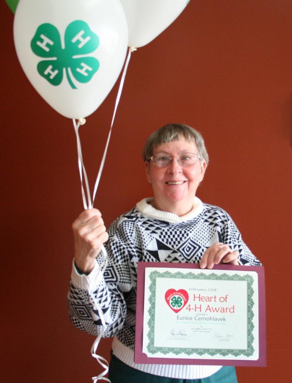 Eunice Cernohlavek holding balloons and a certificate 