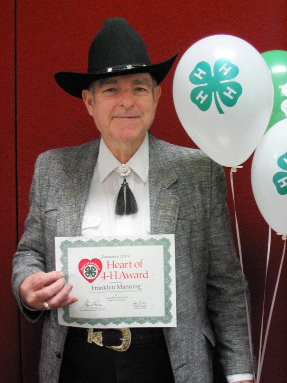 Franklyn Manning holding balloons and a certificate 