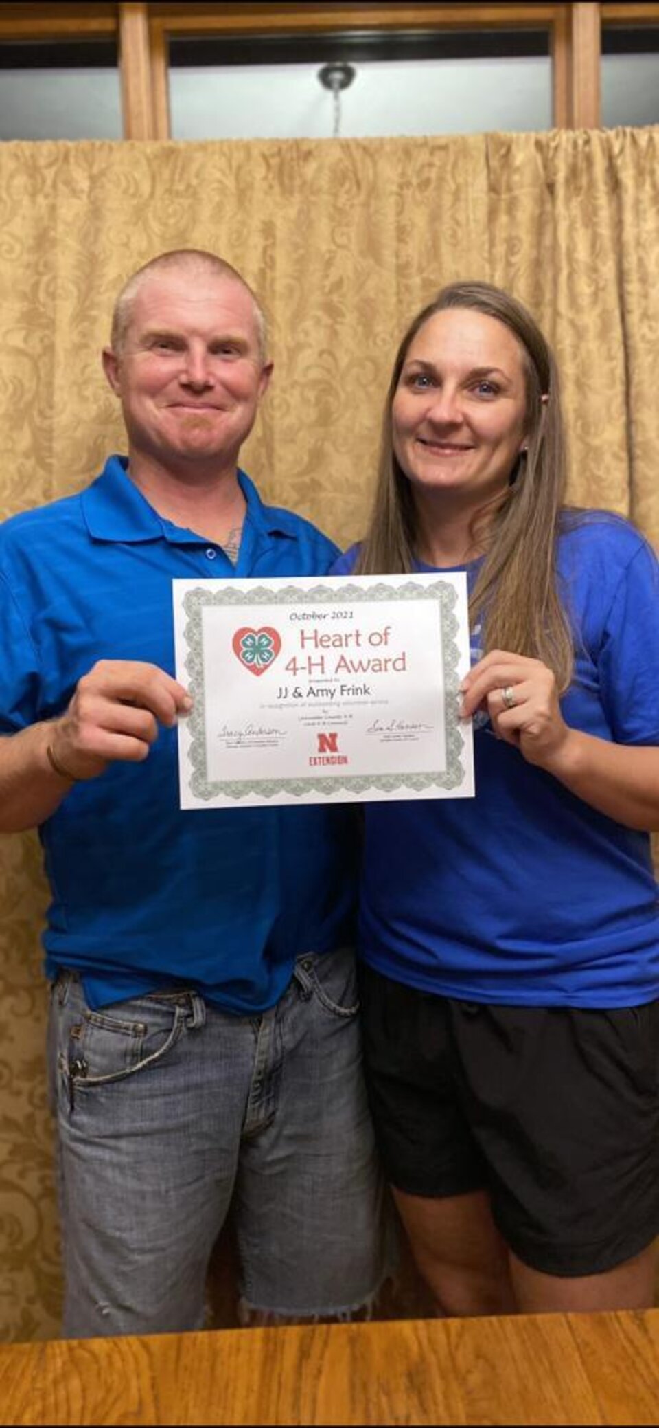 JJ & Amy Frink standing together and holding a certificate. 