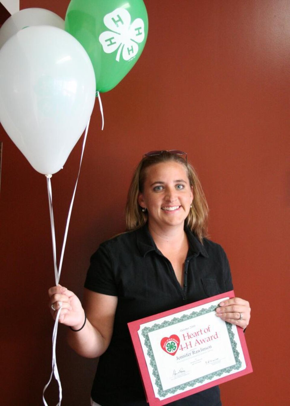 Jennifer Cusick-Rawlinson holding balloons and a certificate 