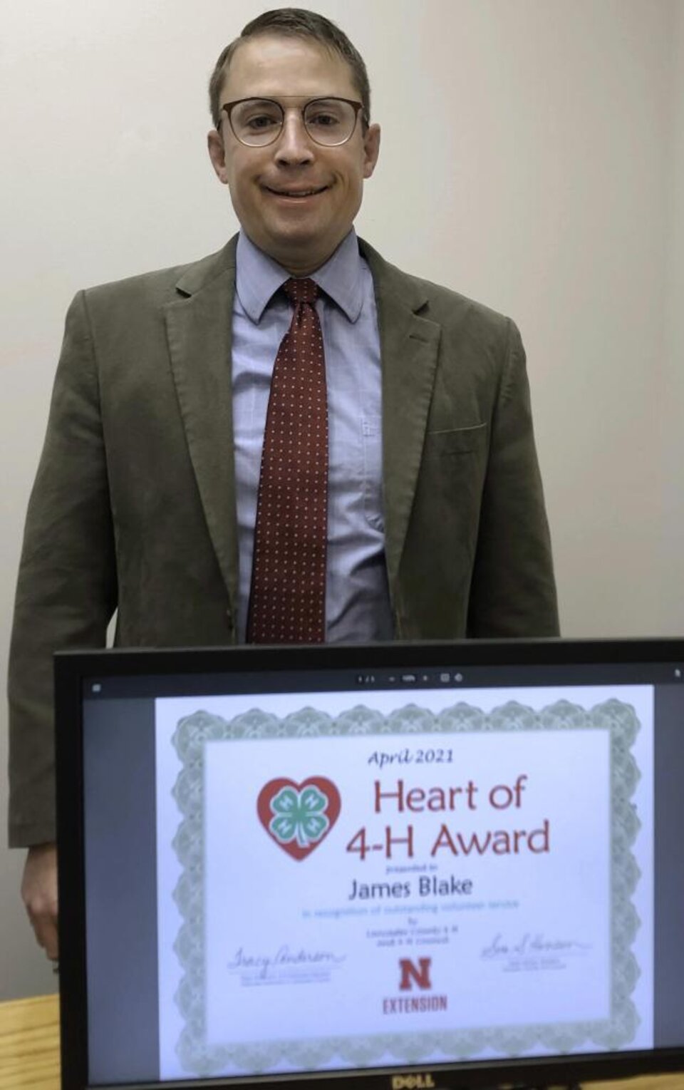 James Blake standing behind a certificate. 