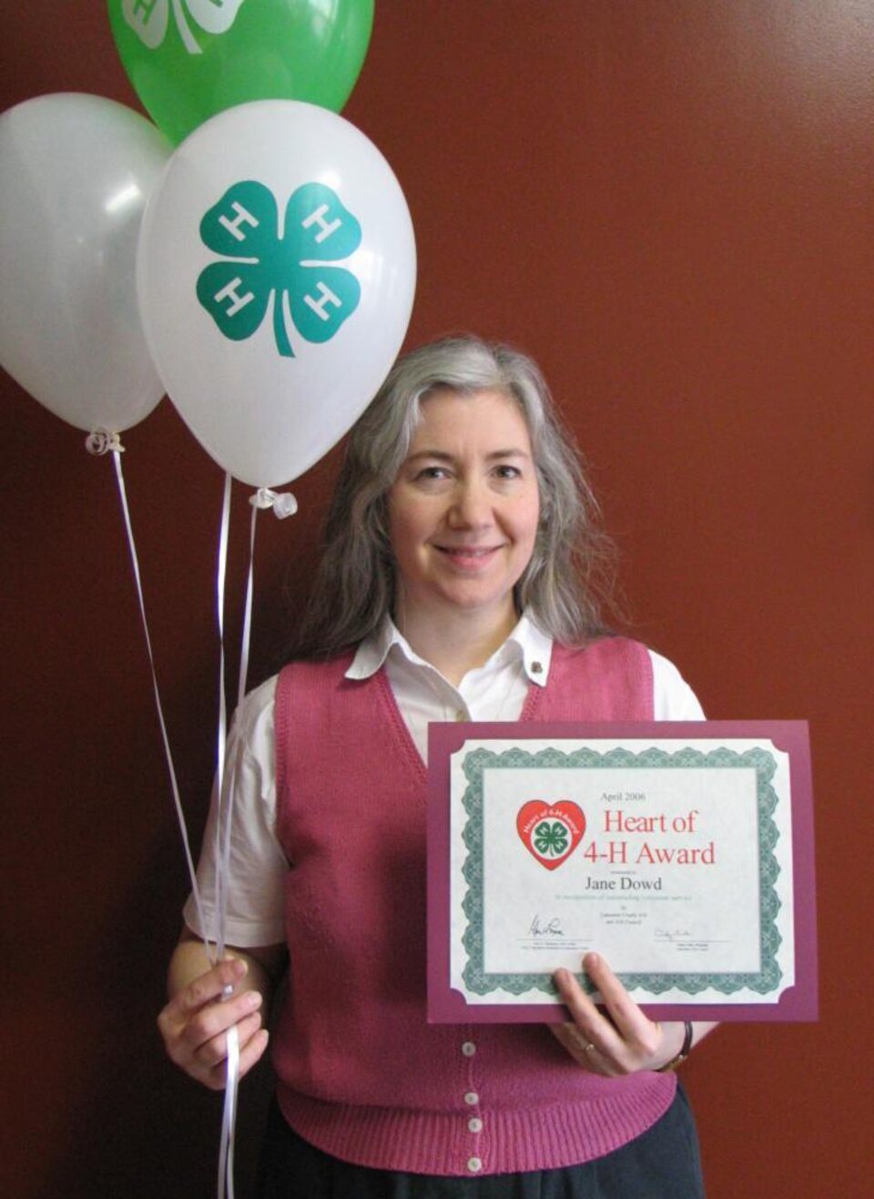 Jane Dowd holding balloons and a certificate 