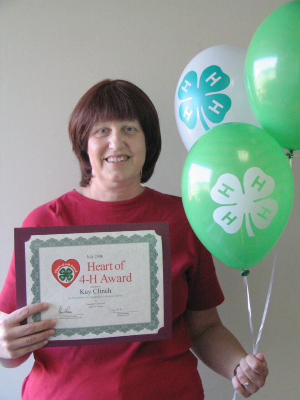 Kay Clinch holding balloons and a certificate 