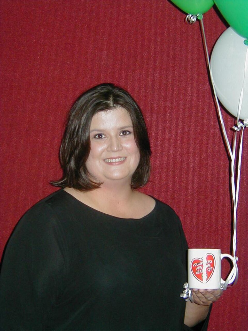 Kala Ball holding balloons and a mug 