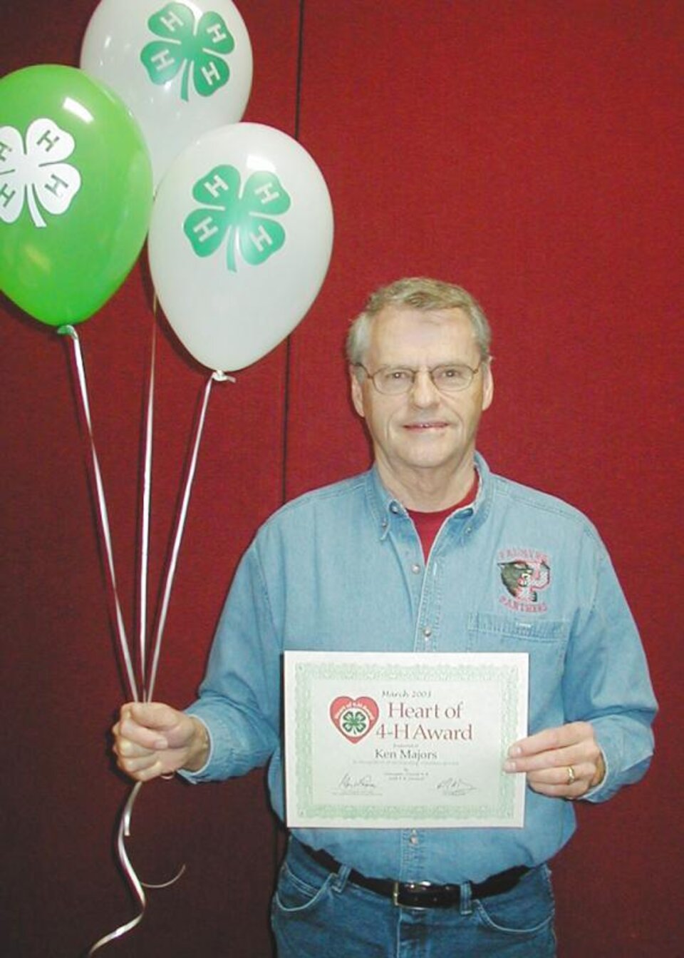 Ken Majors holding balloons and a certificate. 