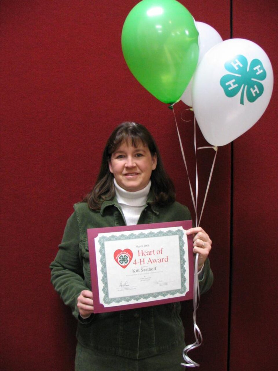 Kitt Saathoff holding balloons and a certificate 