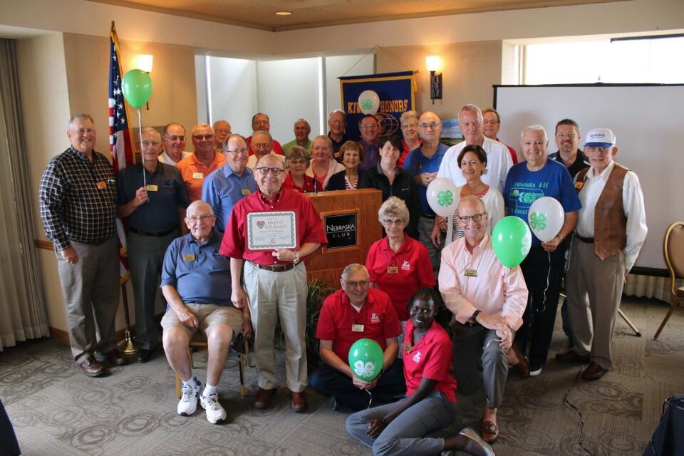 Lincoln Center Kiwanis standing as a group and holding 4-H balloons and a certificate. 