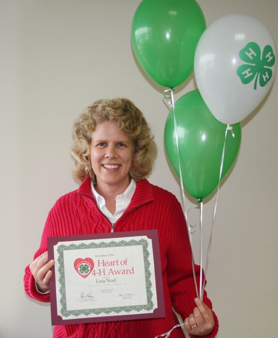 Leia Noel holding balloons and a certificate 