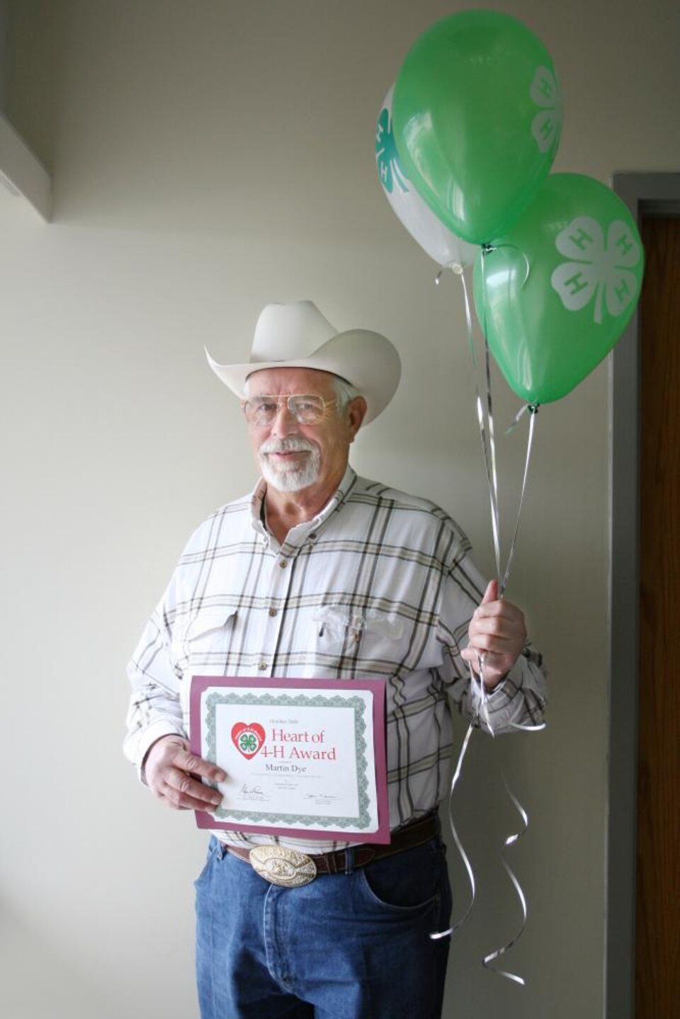 Martin Dye holding balloons and a certificate 