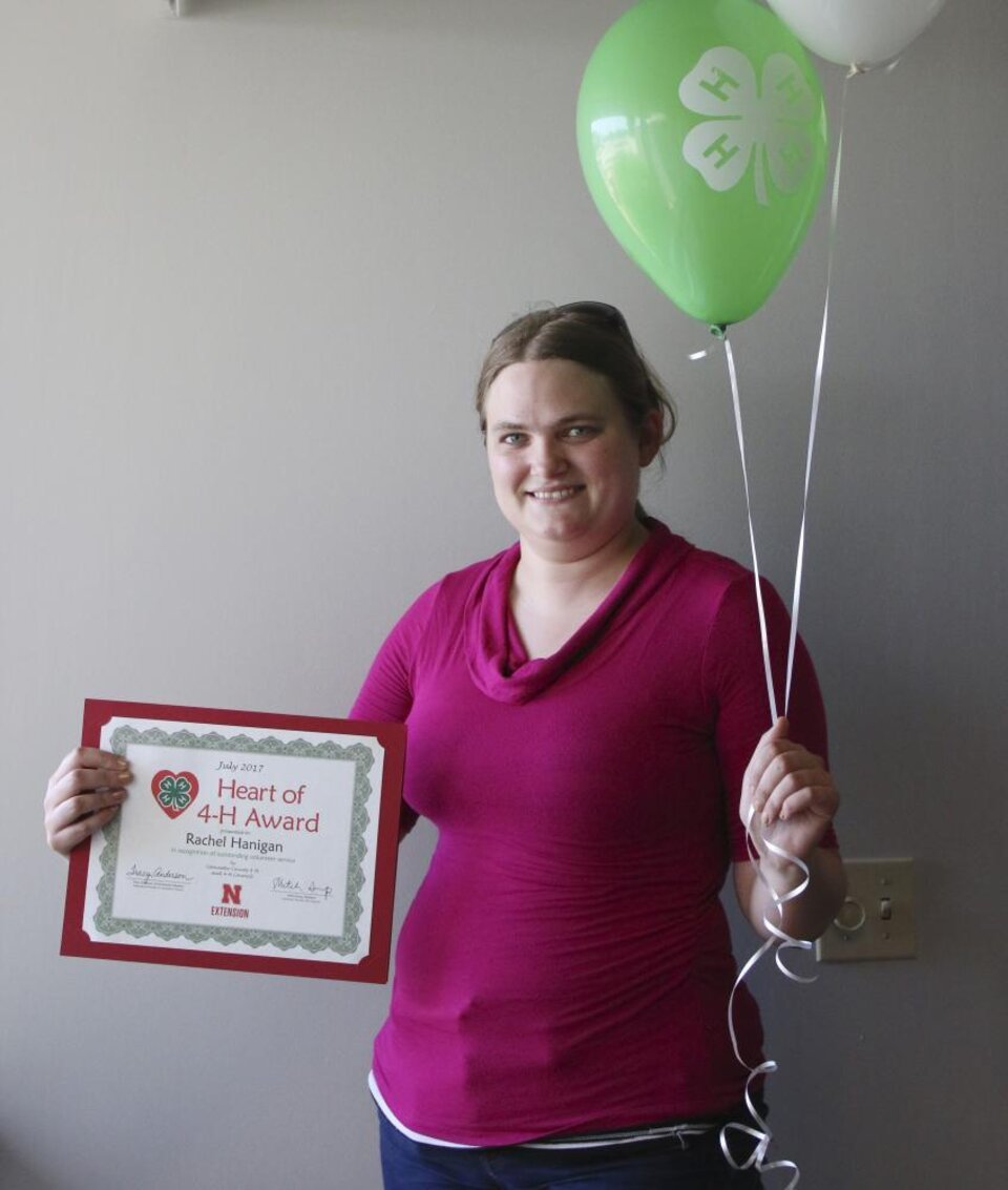 Rachel Hanigan holding 4-H balloons and a certificate 