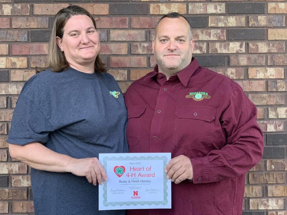 Rusty & Heidi Hanley standing together and holding a certificate. 