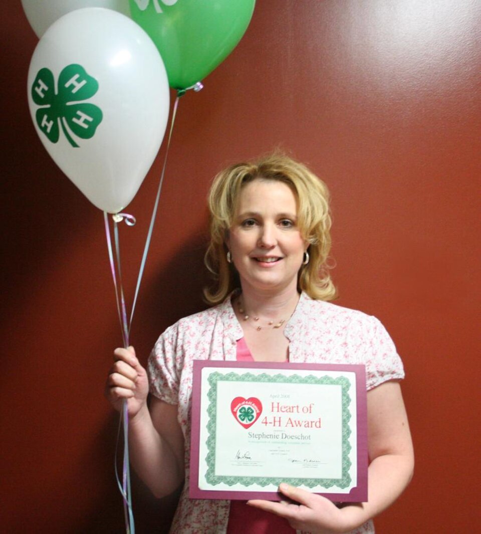 Stephenie Doeschot holding balloons and a certificate 