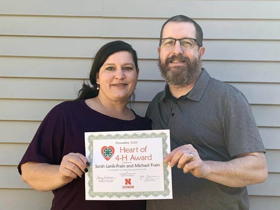 Sarah Lanik-Frain and Mike Frain standing together and holding a certificate. 