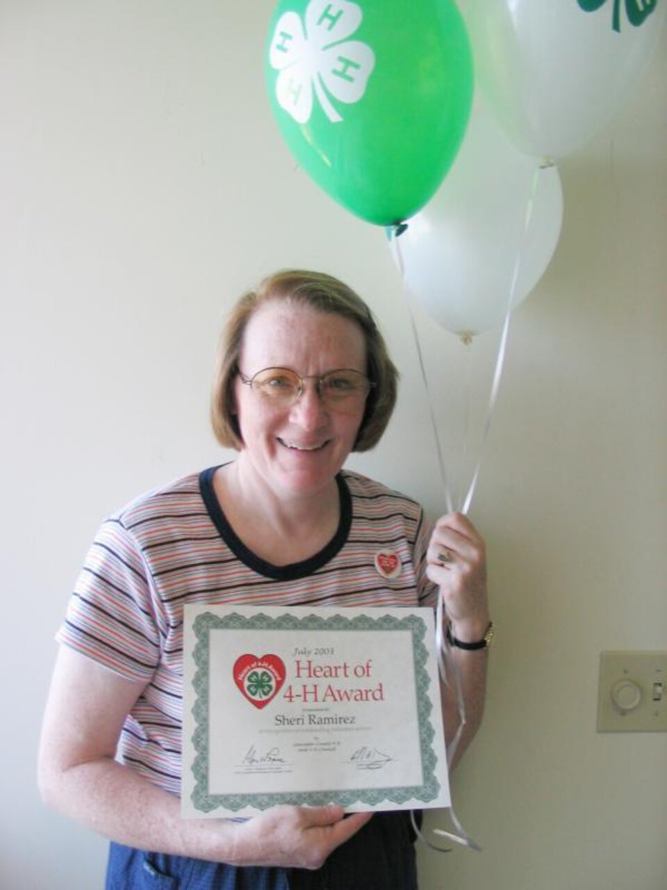 Sheri Ramirez holding balloons and a certificate. 