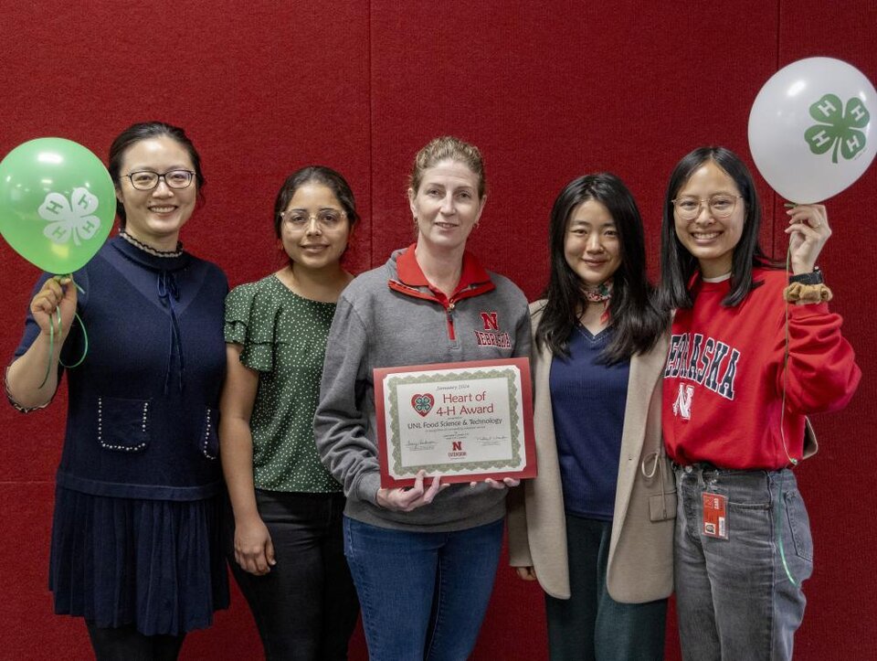 Group of women holding balloons and certificate. 