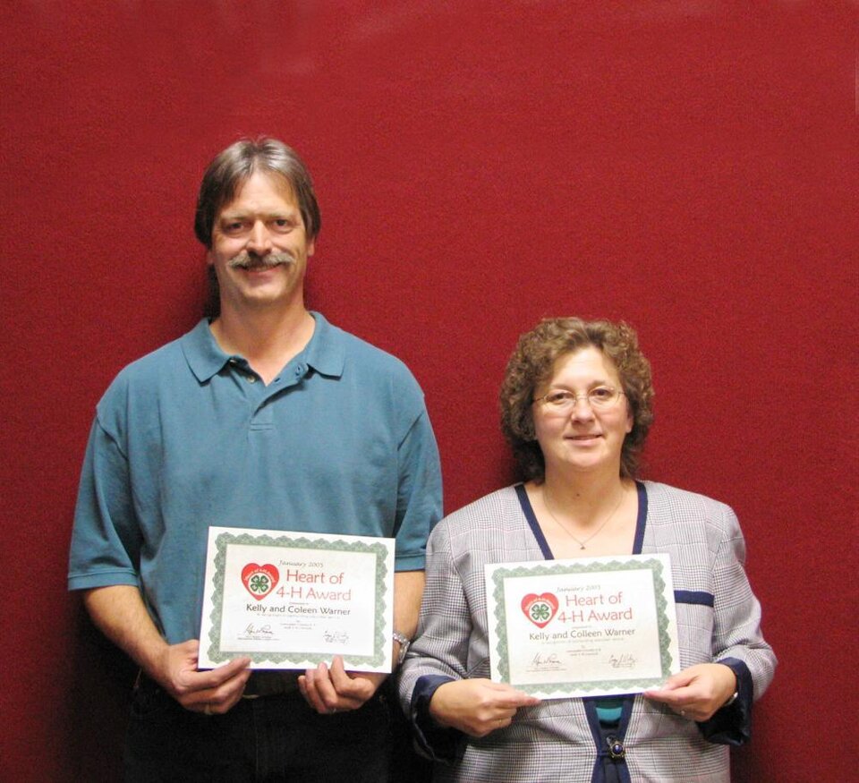 Kelly and Colleen Warner standing next each other, both holding a certificate 